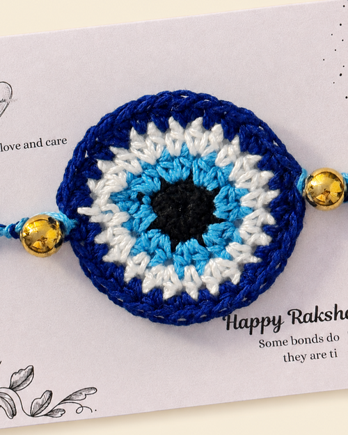 Close-up of the handmade blue, white and black nazar crochet rakhi with gold-tone beads