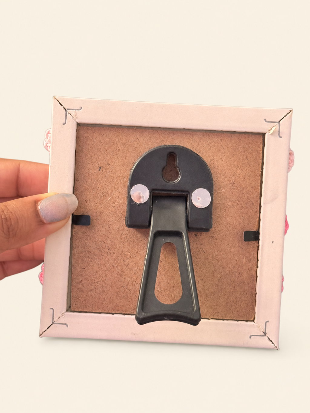 Back of the crochet heart photo frame showing its tabletop stand and wall-hanging slot