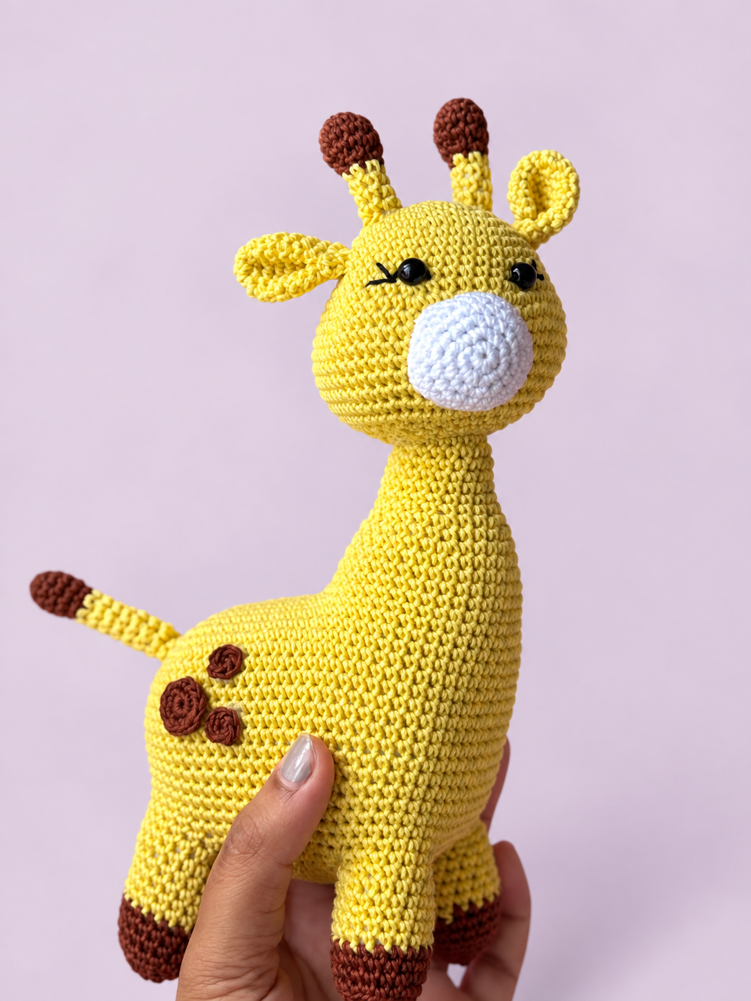 Dottie the Giraffe held in hand for scale
