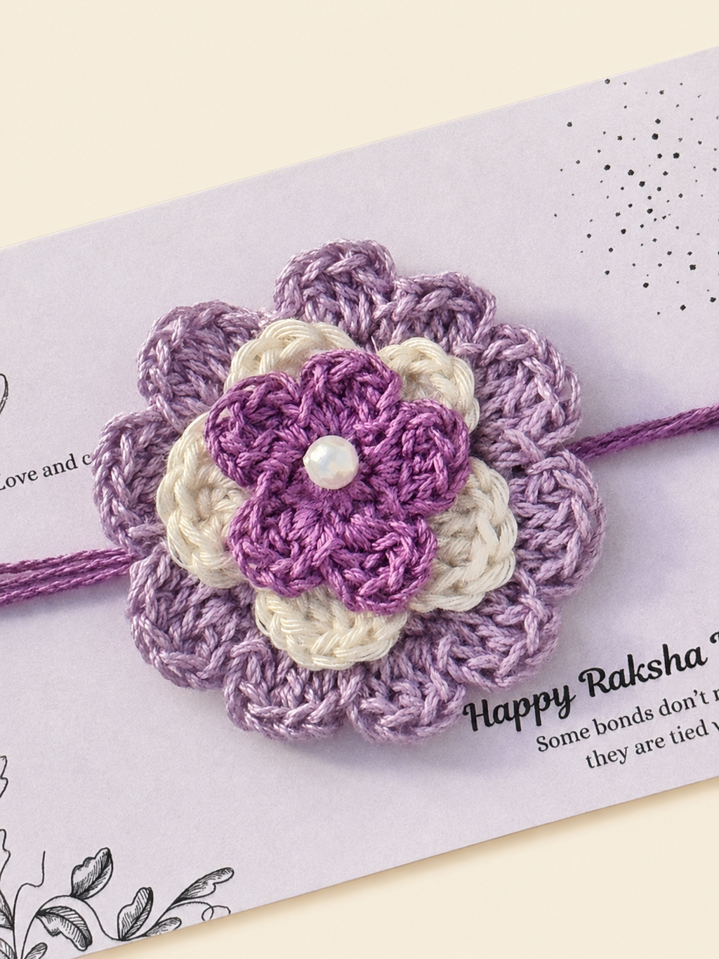 Handmade lavender and cream floral crochet Rakhi on a Raksha Bandhan presentation card