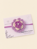 Handmade layered lavender and ivory floral crochet rakhi with purple ties on a Raksha Bandhan presentation card