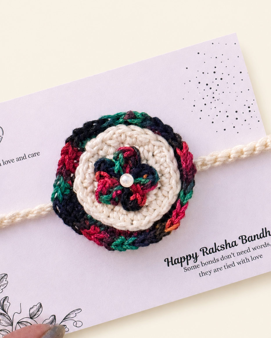 Close-up of multicolour floral handmade crochet rakhi with pearl accent