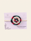 Handmade multicolour floral crochet rakhi with an ivory centre and cream ties on a Raksha Bandhan presentation card