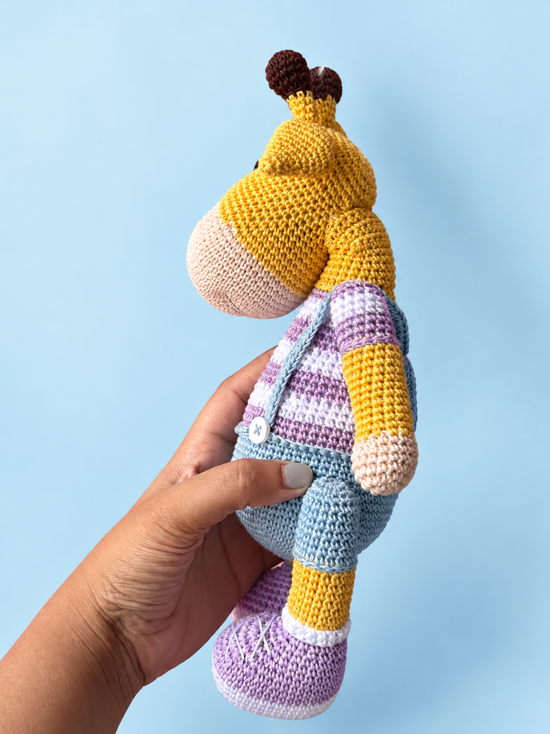 Oliver the Giraffe purple colorway shown in hand