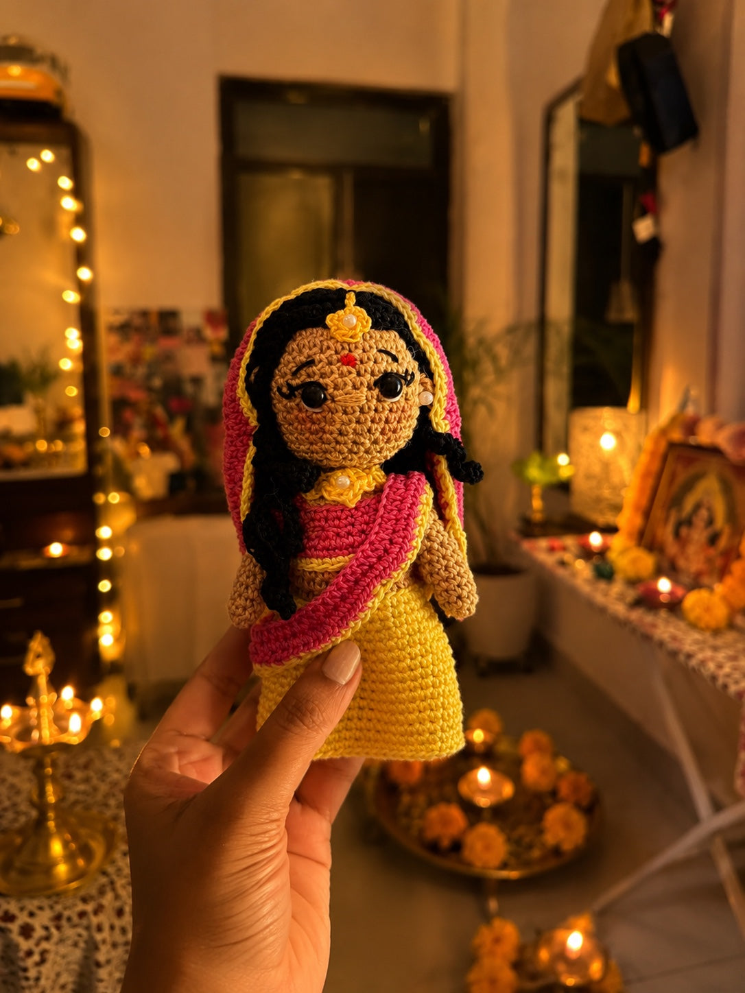 Handmade crochet Radha doll in a warm pooja room setting