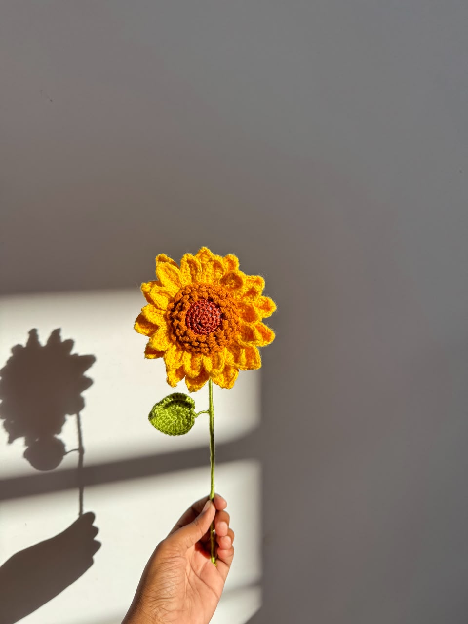 Handheld handmade crochet sunflower by Rubber Band