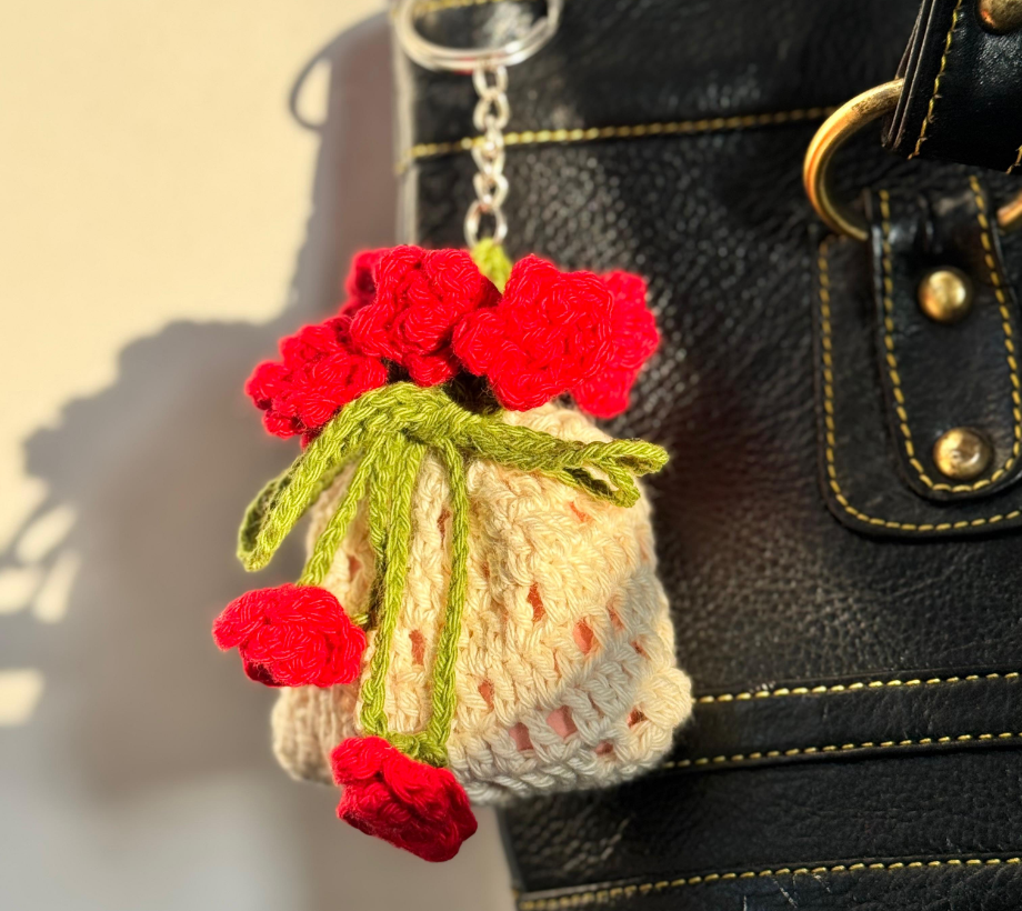 Handmade crochet rose bouquet charm attached to a black handbag