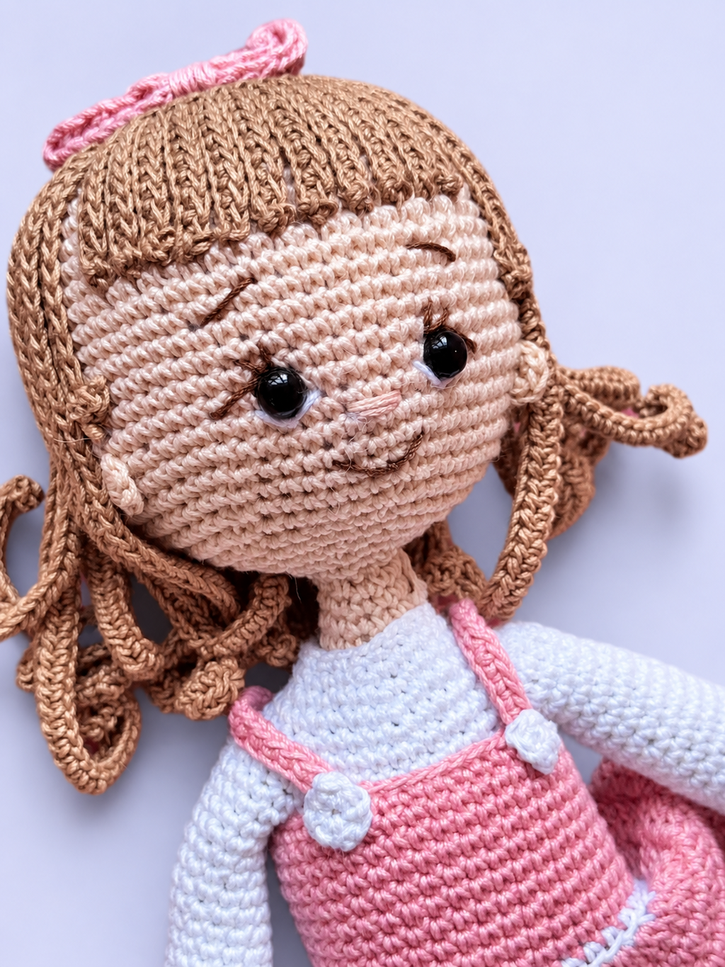 Close-up of Rosie the Doll's face in pink outfit