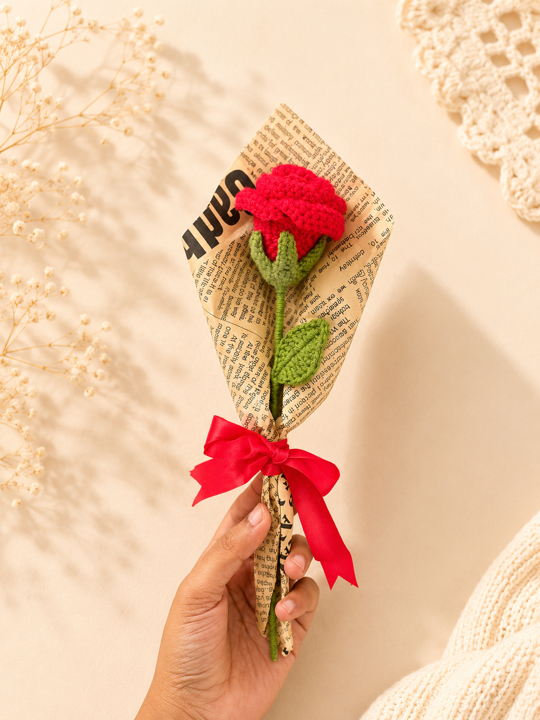 Close view of handmade crochet red rose bouquet held in hand by Rubber Band