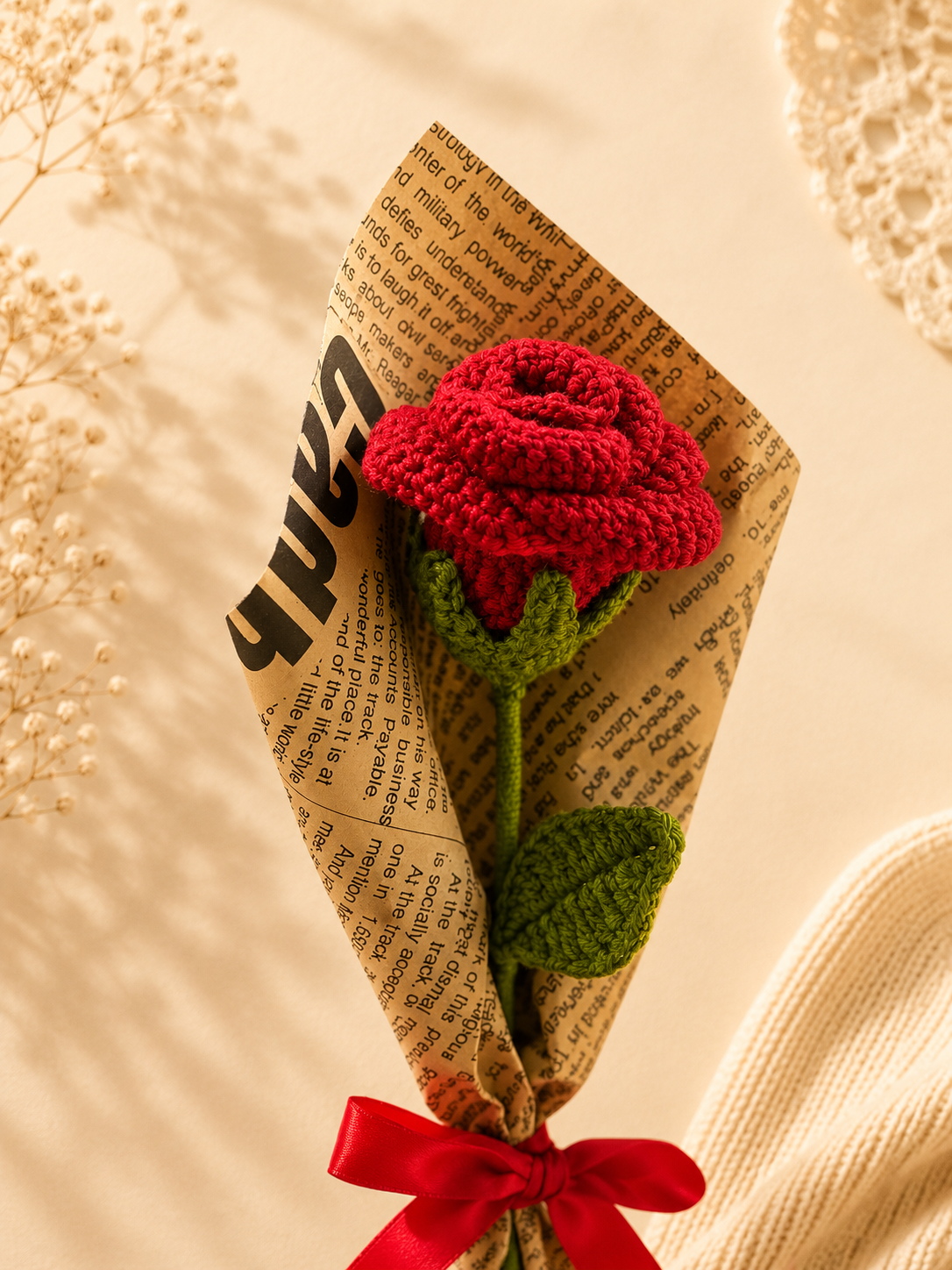 Detailed close-up of handmade crochet red rose petals and leaf by Rubber Band