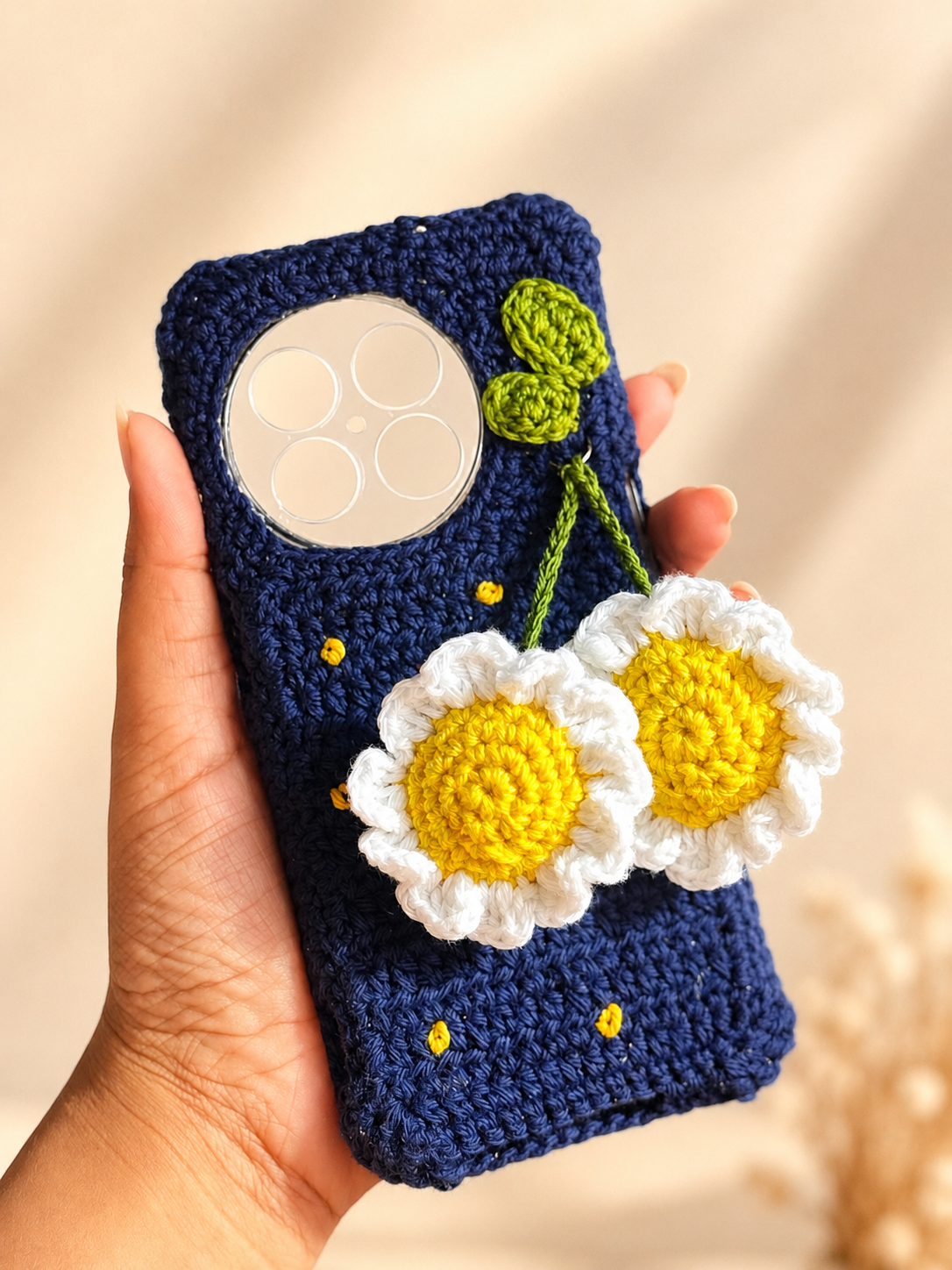 Handmade navy crochet phone cover with two hanging daisy flowers