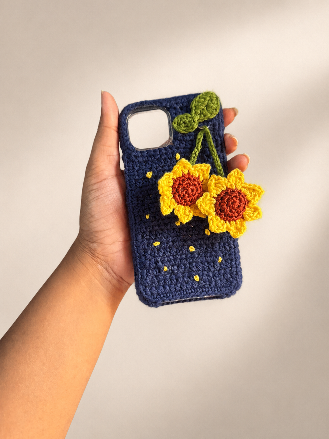Handmade navy crochet phone cover with two sunflower charms