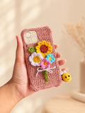 Handmade crochet dusty rose phone cover with colorful flower bouquet and bee charm