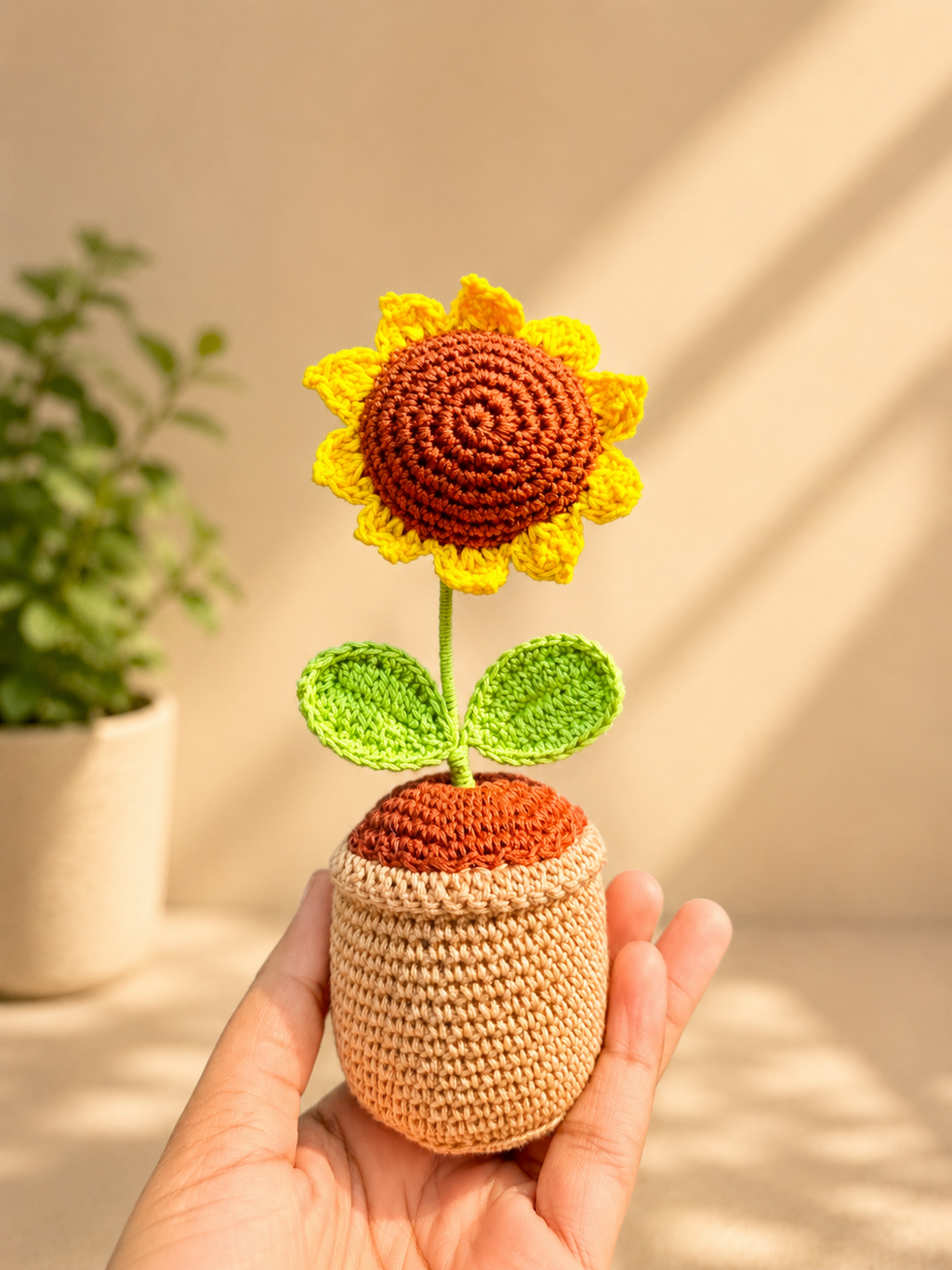 Handmade crochet sunflower flower pot held in hand, front view