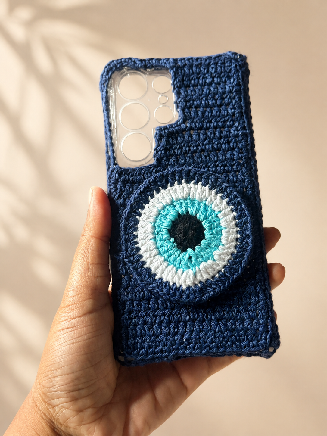 Handmade navy crochet phone cover with raised blue evil eye design