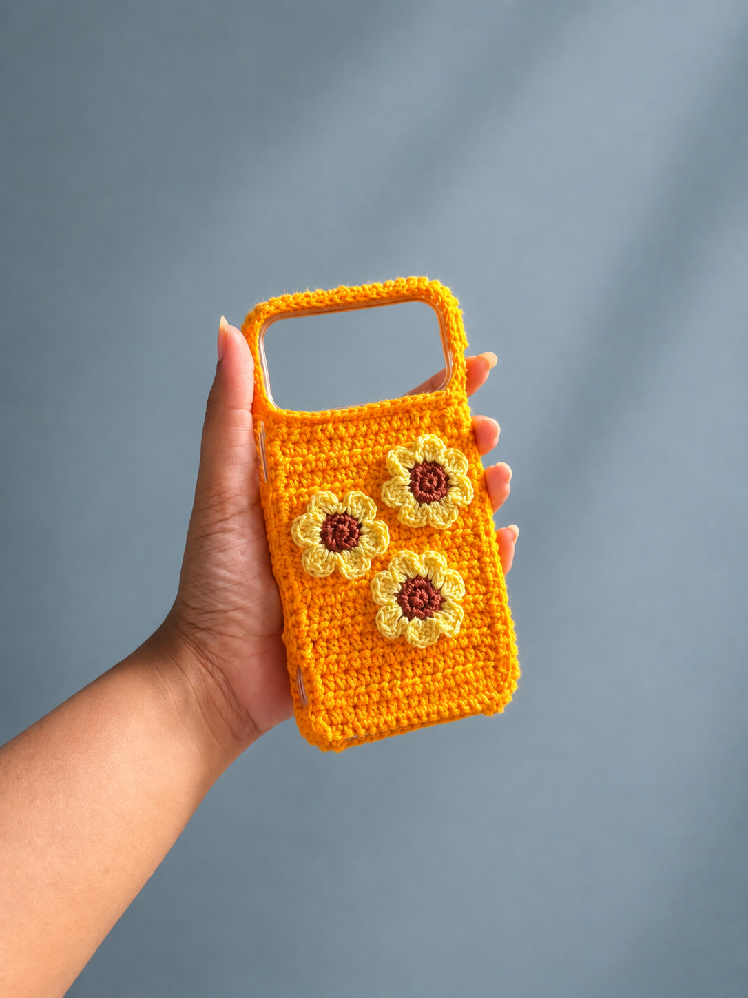 Handmade orange crochet phone cover with three sunflower flowers