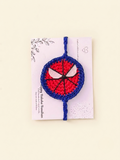 Handmade red and blue Spider-Man crochet rakhi on a Raksha Bandhan presentation card