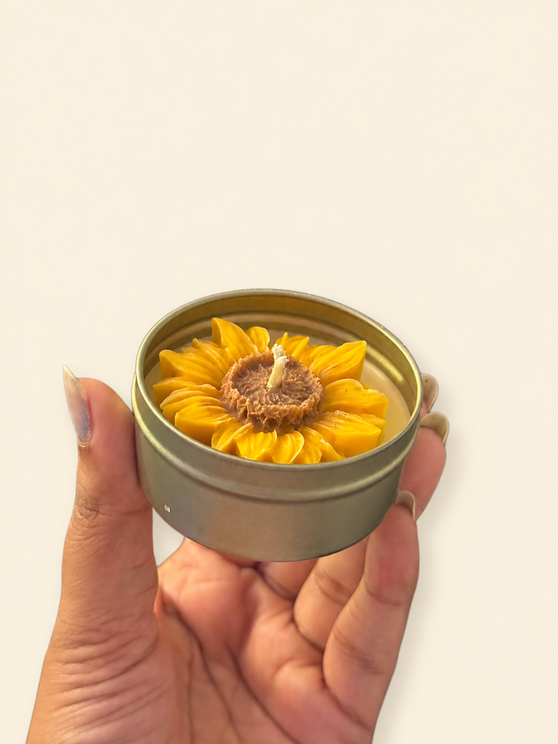Sunflower-shaped candle in a reusable metal tin included in the Rakhi gift set
