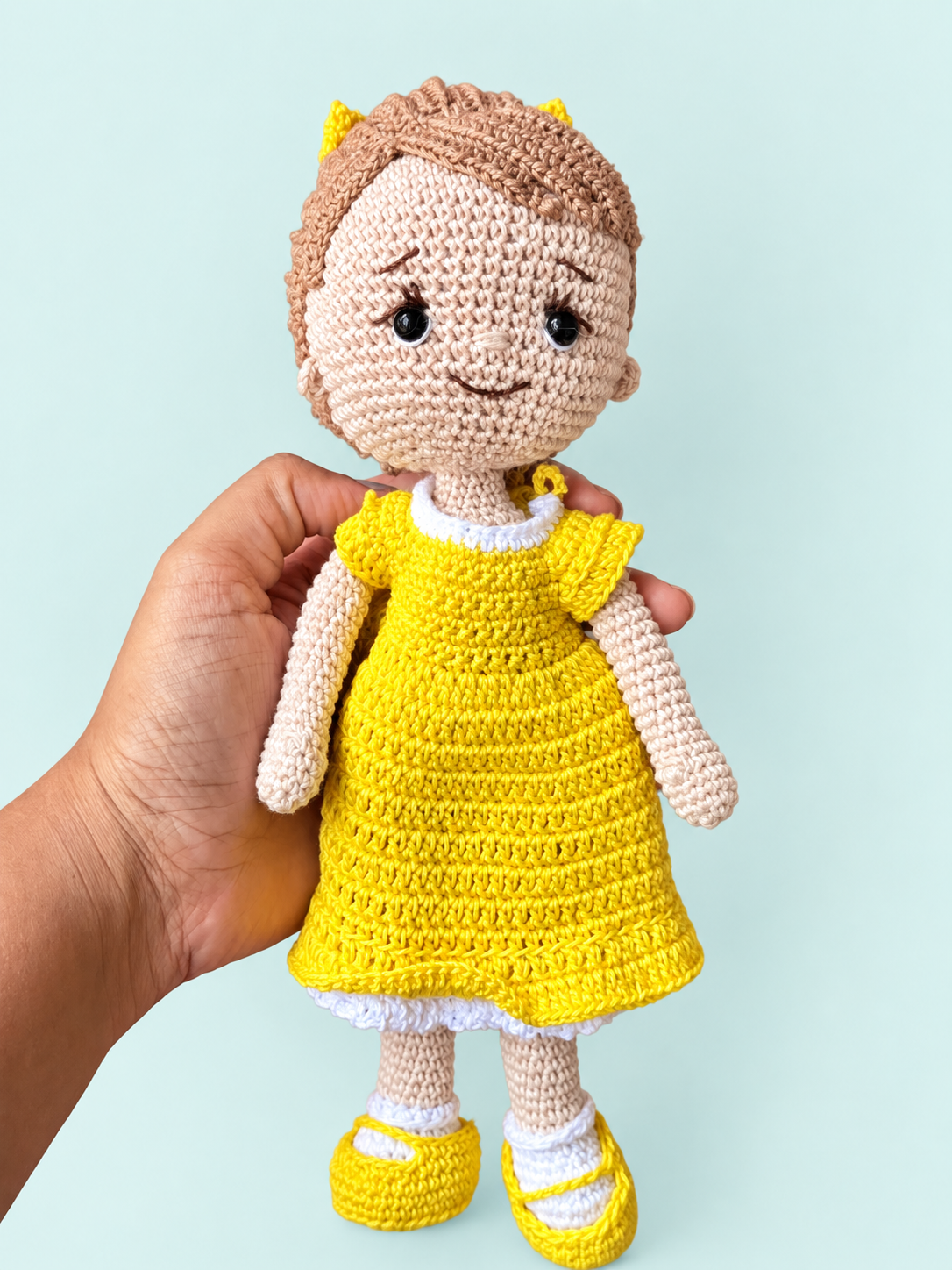 Sunny the Doll in yellow dress held in hand for scale